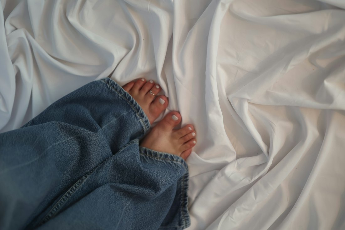 Pés descansando sobre lençol branco